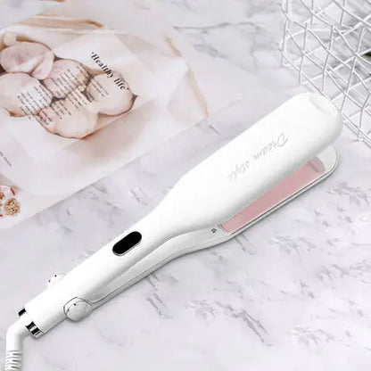 White and pink hair straightener on a marble surface with a blurred background